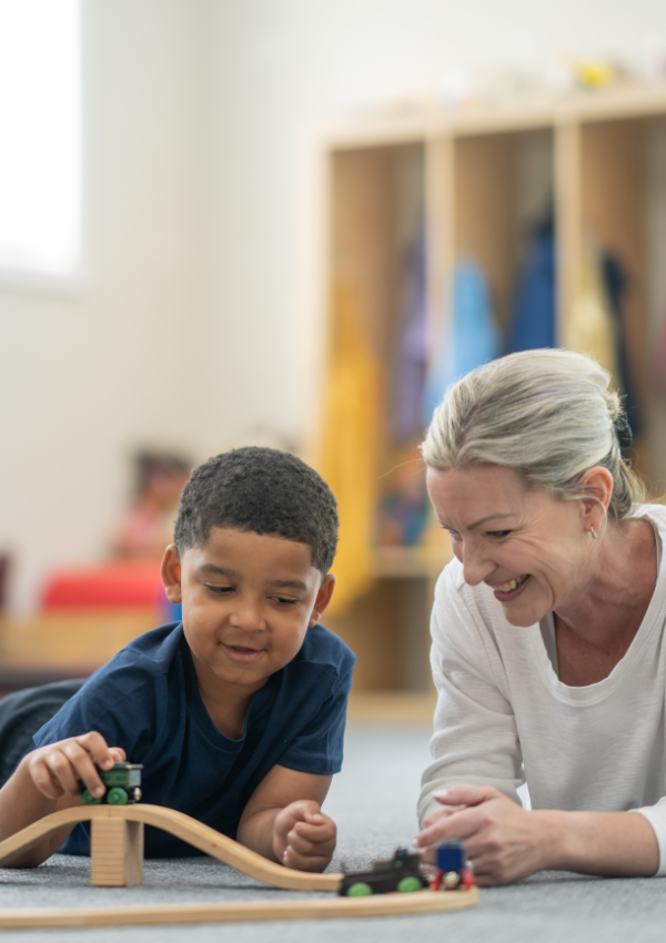 ABA therapy near me showing a therapist engaging a child in a play-based learning activity with toy trains